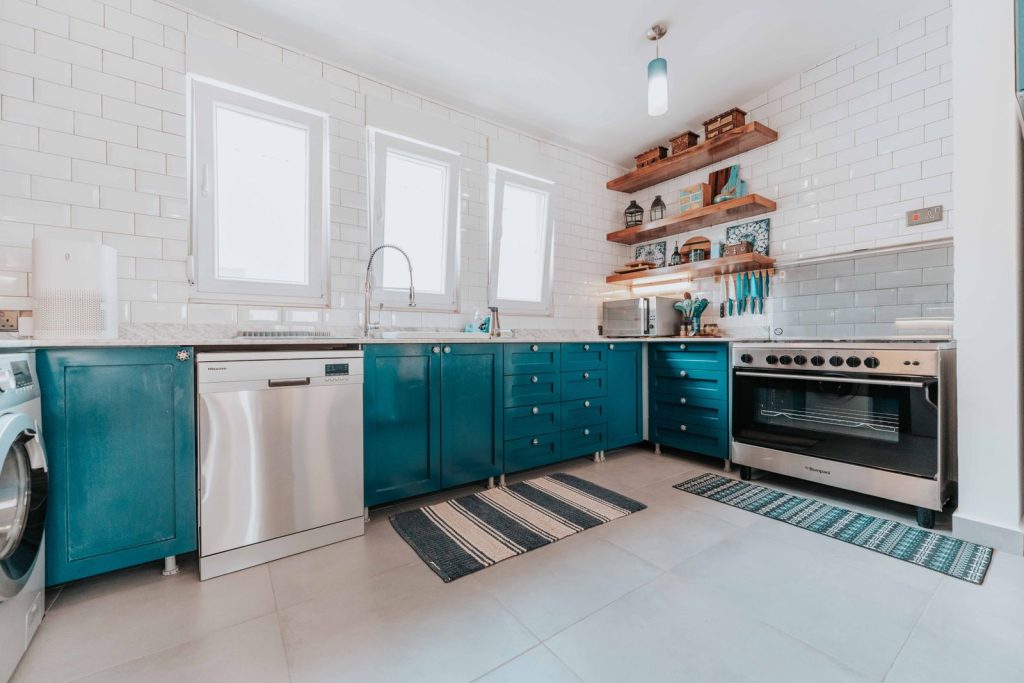 Cuisine avec sol carrelé et petits tapis devant l’évier et la cuisinière