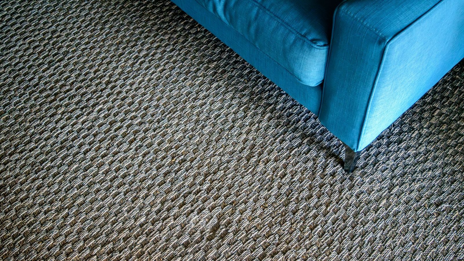 angle de canapé posé sur un tapis tissé à la texture marquée