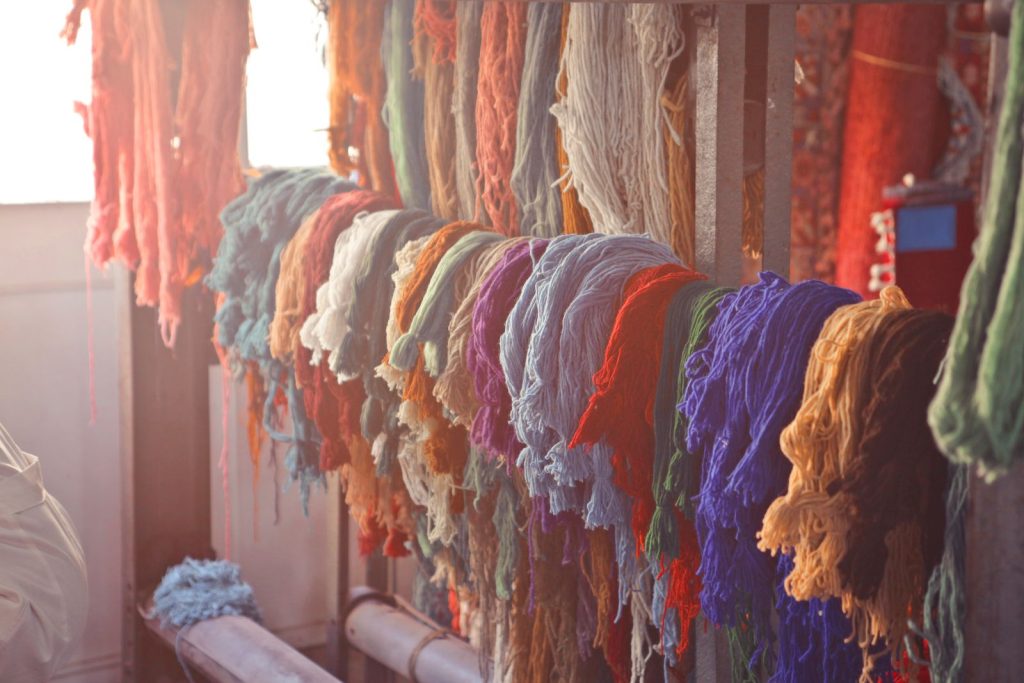 Écheveaux de fils multicolores suspendus dans un atelier textile.