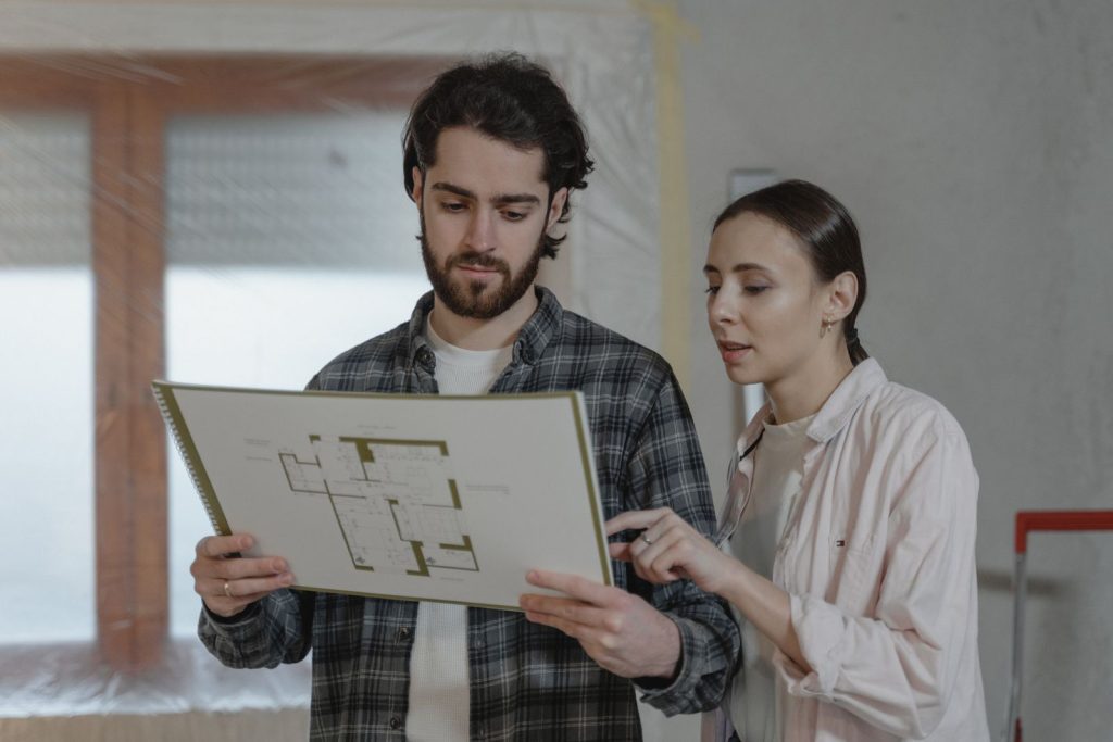 Un homme et une femme examinent ensemble un plan de rénovation