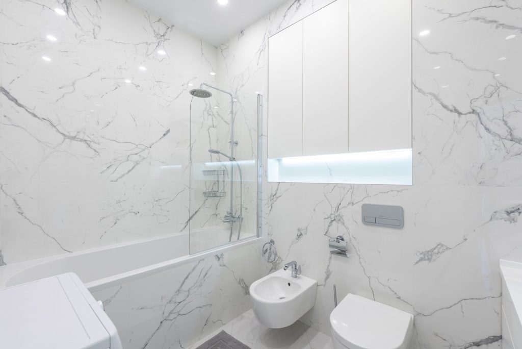 Salle de bain moderne avec sol et murs en carrelage blanc