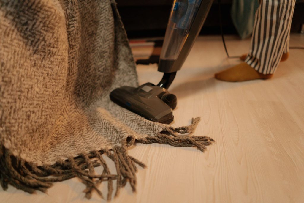 Aspirateur passé sur un tapis en laine posé au sol pour l’entretenir