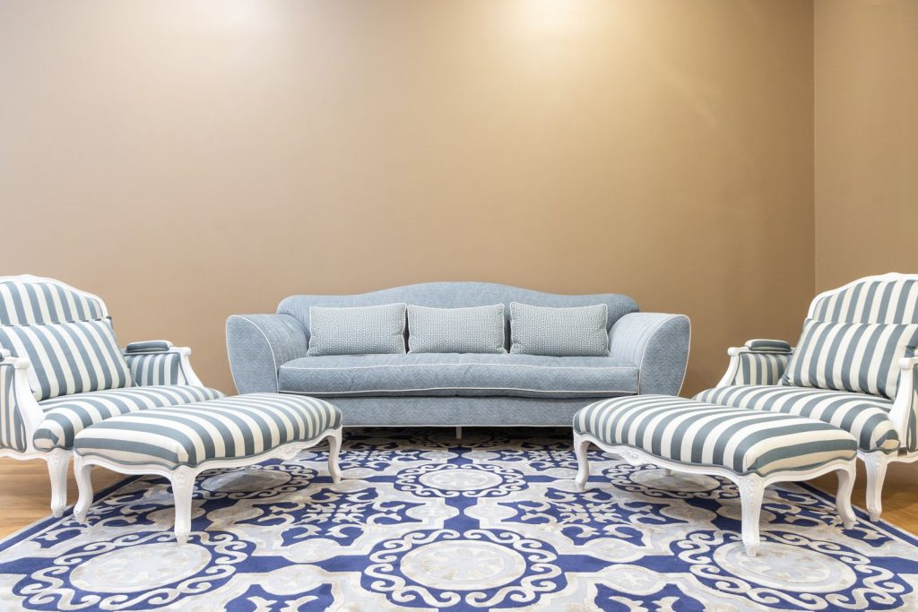 Salon habillé d’un tapis à motifs colorés et de fauteuils rayés