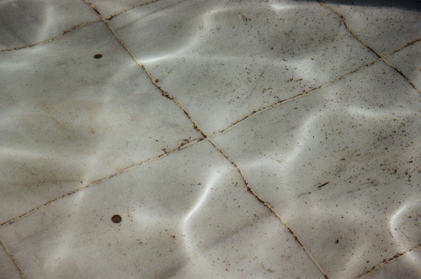 Résidus de calcaire blanc sur un sol carrelé