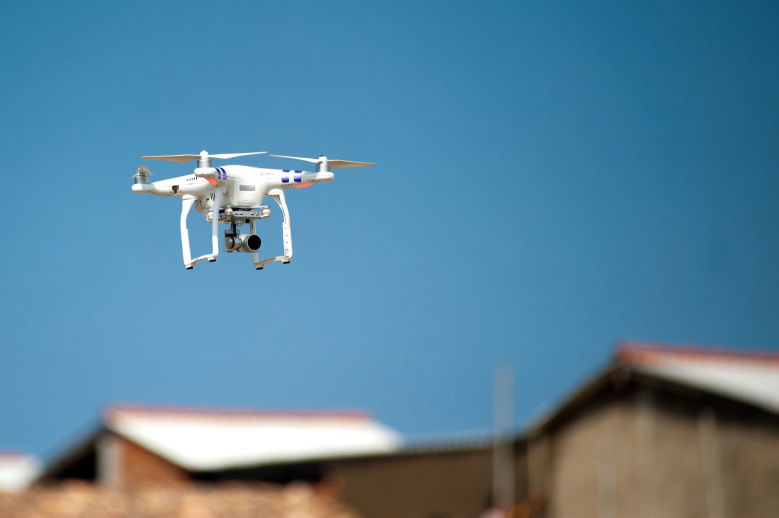 Drone quadricoptère en vol d'inspection au-dessus d'une toiture
