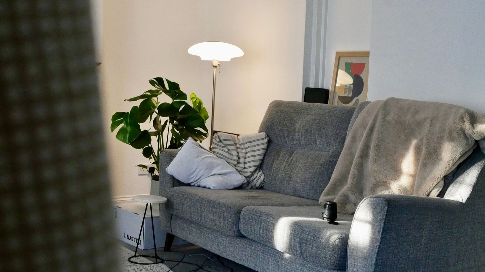 Lampadaire d'angle éclairant un canapé et un tapis dans un salon