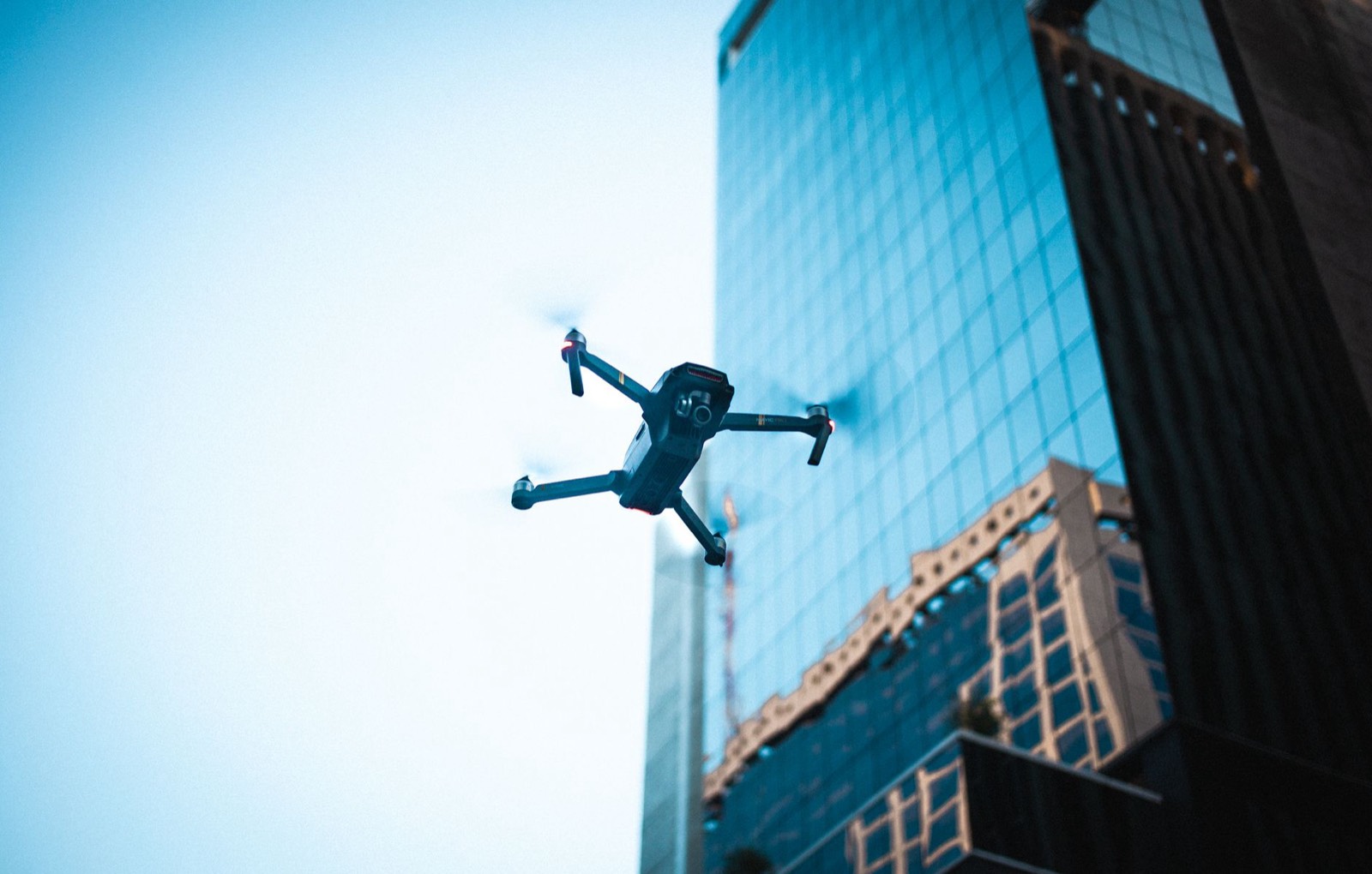 Drone pulvérisant un produit de nettoyage sur la façade d'un bâtiment